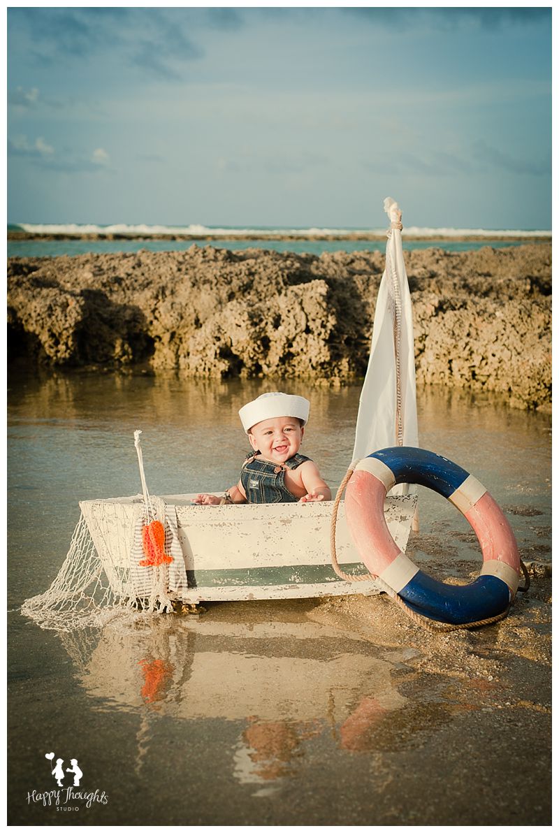 baby boy on a boat at the beach