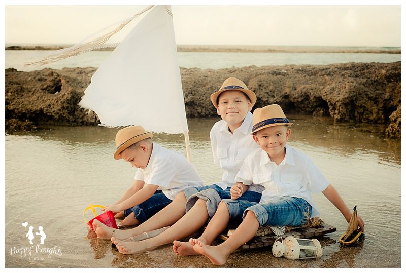 Boys at beach on a wooden sail raft